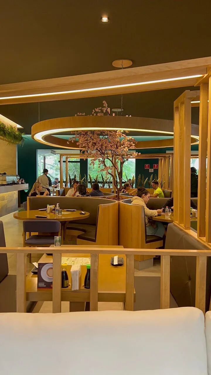 Salão do Taki Sushi São Roque, com mesas e decoração de cerejeira